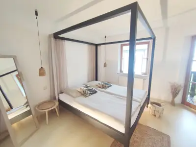 Schlafzimmer mit Himmelbett und Zugang zum Balkon