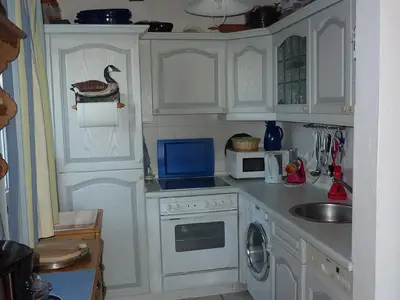 Kochbereich. Küche mit Kühl-/Gefrierkombi, Ceranherd, Backofen, Waschmaschine, Mikrowelle und Geschirrspüler