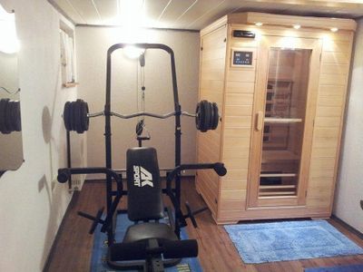 Fitnessraum mit Sauna, Fitnessgerät und Dusche