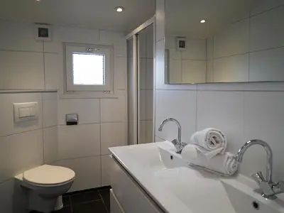 Badezimmer mit Doppelwaschbecken&comma; WC und Dusche