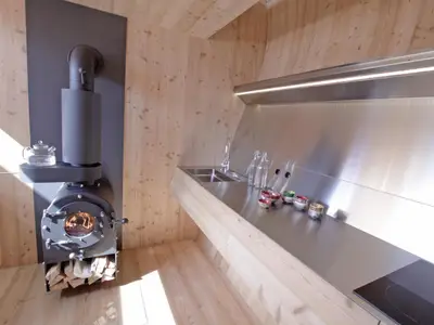 Kochbereich. Holzofen mit Speicher und Küchenzeile