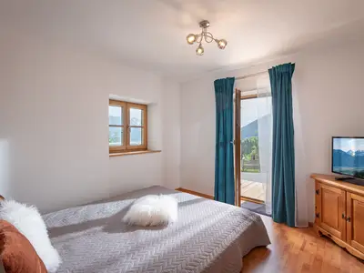 Schlafzimmer mit Doppelbett und Zugang zum Balkon