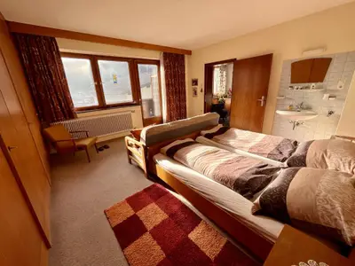 Schlafzimmer mit Doppelbett, Sofa Couch und Balkon