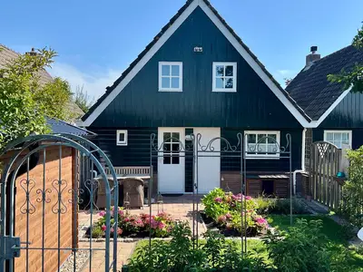 Blick vom Deich auf den Garten, mit Grill und Sitzmöglichkeiten.
