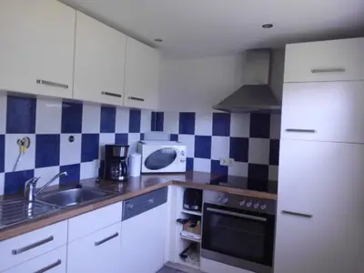 Küche mit Geschirrspüler, Backofen, Kühl-Gefrierkombination und Ceranfeld