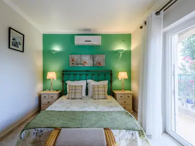 Schlafzimmer im Erdgeschoss 1 mit Bad und Türen zum Garten und Pool