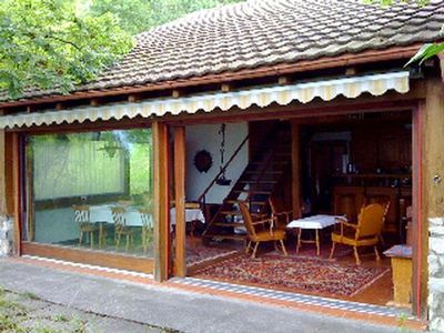 Südfront mit Panorama-Schiebe-Fenstern, die sich zu 50% zur sehr großen, mit Steinplatten belegten Terrasse öffnen 