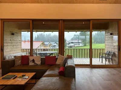 Sitzbereich mit Fensterfront und Balkon im Hintergrund