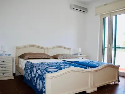 Villa Vittoria: großes Schlafzimmer mit Klimaanlage und Blick zum Balkon