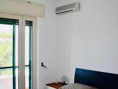 Villa Vittoria: kleines Schlafzimmer mit Klimaanlage und Blick zum Balkon