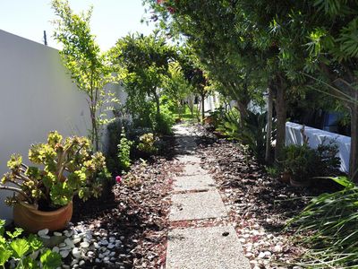 Außenansicht des Gebäudes. Garten neben dem Garageneingang