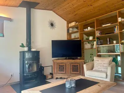 Wohnzimmer OG offen in Richtung Esszimmer mit Ofen und TV