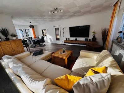 Unteres Wohnzimmer mit 75 Zoll Smart TV und Essbereich mit direkten Zugang zum Bakon mit Grill