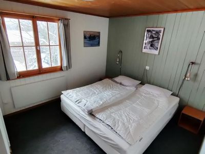 Nochmals das gemütliche Schlafzimmer 1 bei Tageslicht im Schneegestöber. Wandschrank vorhanden.