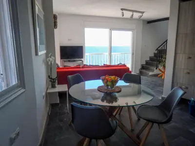 Wohnbereich. Das offene Wohnzimmer/Küche hat viel Licht und riesige Schiebefenster mit Blick auf den Ozean.