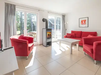 Wohn-Essbereich mit Couch, Kamin und Zugang zur Terrasse