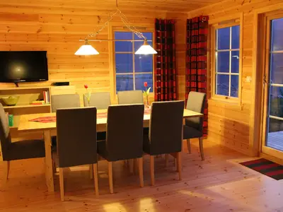 Wohnzimmer mit großem Tisch und TV