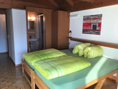 Doppelschlafzimmer mit Dusche/WC und Balkon mit Sicht auf See und Berge