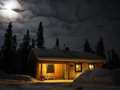 Außenansicht des Gebäudes. Blockhütte bei Vollmond im Winter