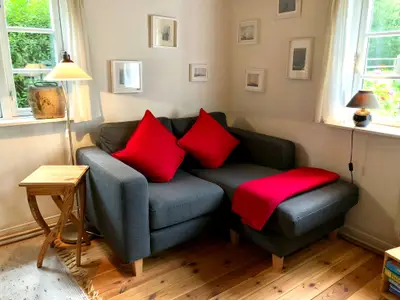 Ein kleines 2er Sofa im Wohnzimmer mit Kamin und TV