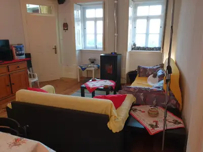 Das Wohnzimmer mit Sitzecke und Eingang und Pelletofen