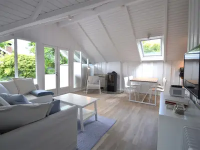 Wohnbereich mit Ofen, gemütlichem Sofa und Blick auf die Terrasse