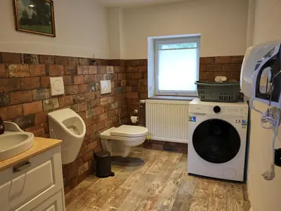 WC mit Waschmaschine, Bügelbrett und Bügeleisen