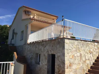 Villa mit großer Terrasse und Zugang zum Hauseingang (oben) und Zugang zur Terrasse (rechts)