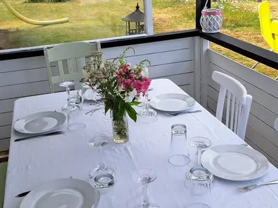 überdachte Terrasse hinter dem Haus. Tisch mit Platz für 6 Personen.