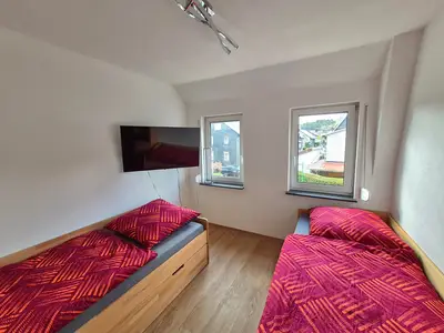 2 Personen schlafen in gemütlichen Einzelbetten. Für Unterhaltung sorgt der schwenkbare TV.