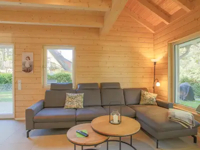Einfamilienhaus Am Hafen 21 in Zieslow — gemütliches Wohnzimmer mit Holzvertäfelung, Ecksofa und Blick in den Garten