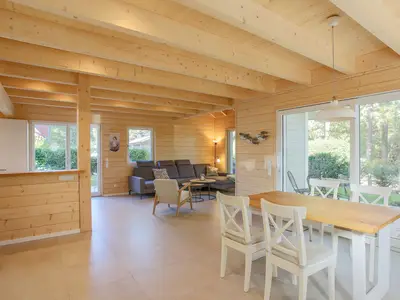 Einfamilienhaus Am Hafen 21 in Zieslow — offener Wohn-Essbereich mit Holzdecke, großer Schiebetür zur Terrasse