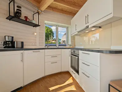 Ferienhaus Nordkugel – Kugelhaus am Tollensesee – moderne vollausgestattete Einbauküche mit Fenster ins Grüne