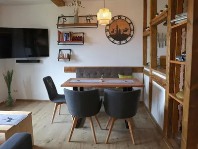 Wohnzimmer mit Esstisch und ausziehbarer Couch