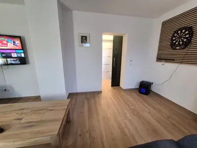 Wohnzimmer mit TV, Soundanlage und Dartscheibe