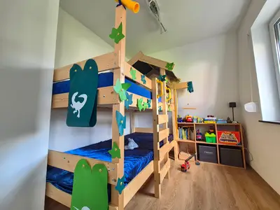 Liebevoll eingerichtetes Kinderzimmer mit Abenteuer-Stockbett, Büchern und viel Spielzeug.