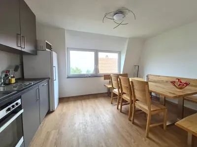 Komplett eingerichtete Küchenzeile mit Herd, Backofen, Dunstabzugshaube und Spülmaschine. Gemütlich sitzt es sich am Bau