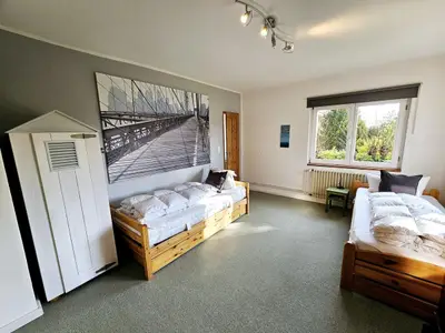 Geräumiges Schlafzimmer mit natürlichem Licht und einladenden Betten.