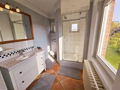 Modernes Badezimmer mit eleganter Dusche und stilvollem Waschbecken.