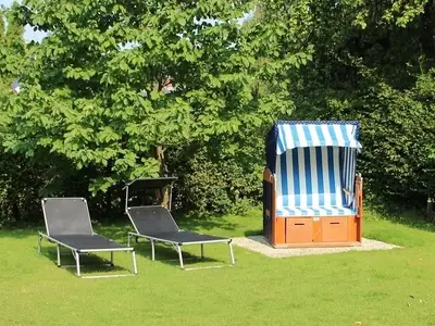 Genießen Sie entspannte Stunden auf dieser großzügigen Terrasse mit Liegen und Strandkorb.