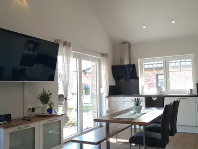 Moderne Küche mit Esstisch und Fernseher