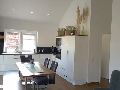 Moderne Küche mit Esstisch und Geräten