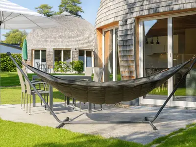 ChatGPT:Private Terrasse am Ferienhaus Nordkugel – mit Hängematte, Esstisch und Sonnenschirm für entspannte Stunden