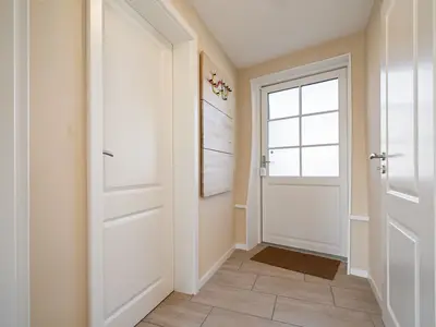 ChatGPT:Ferienhaus Nordkugel – Kugelhaus am Tollensesee – heller Eingangsbereich mit stilvollen Details und Garderobe