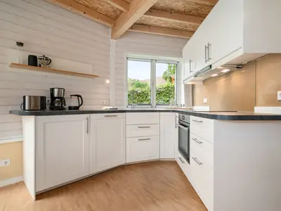 Ferienhaus Nordkugel – Kugelhaus am Tollensesee – moderne vollausgestattete Einbauküche mit Fenster ins Grüne