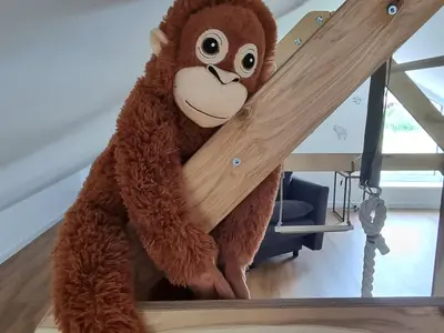 Plüschfigur auf Holzleiter in Spielraum