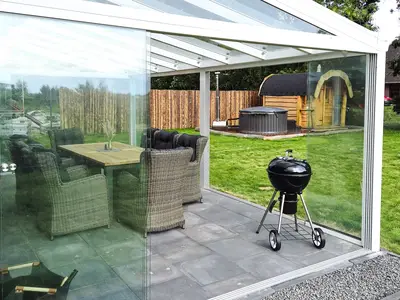 Überdachte Terrasse mit Sitzgruppe und Grill