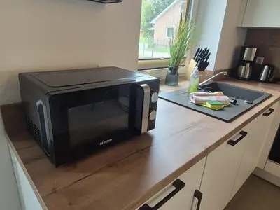 Moderne Küche mit Mikrowelle und Spüle.