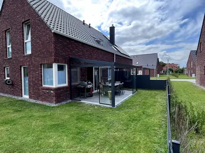 Außenansicht eines Hauses mit Rasen und Garten.