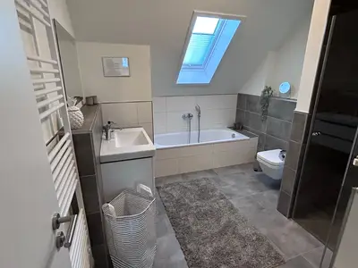 Modernes Badezimmer mit Badewanne und Waschbecken.